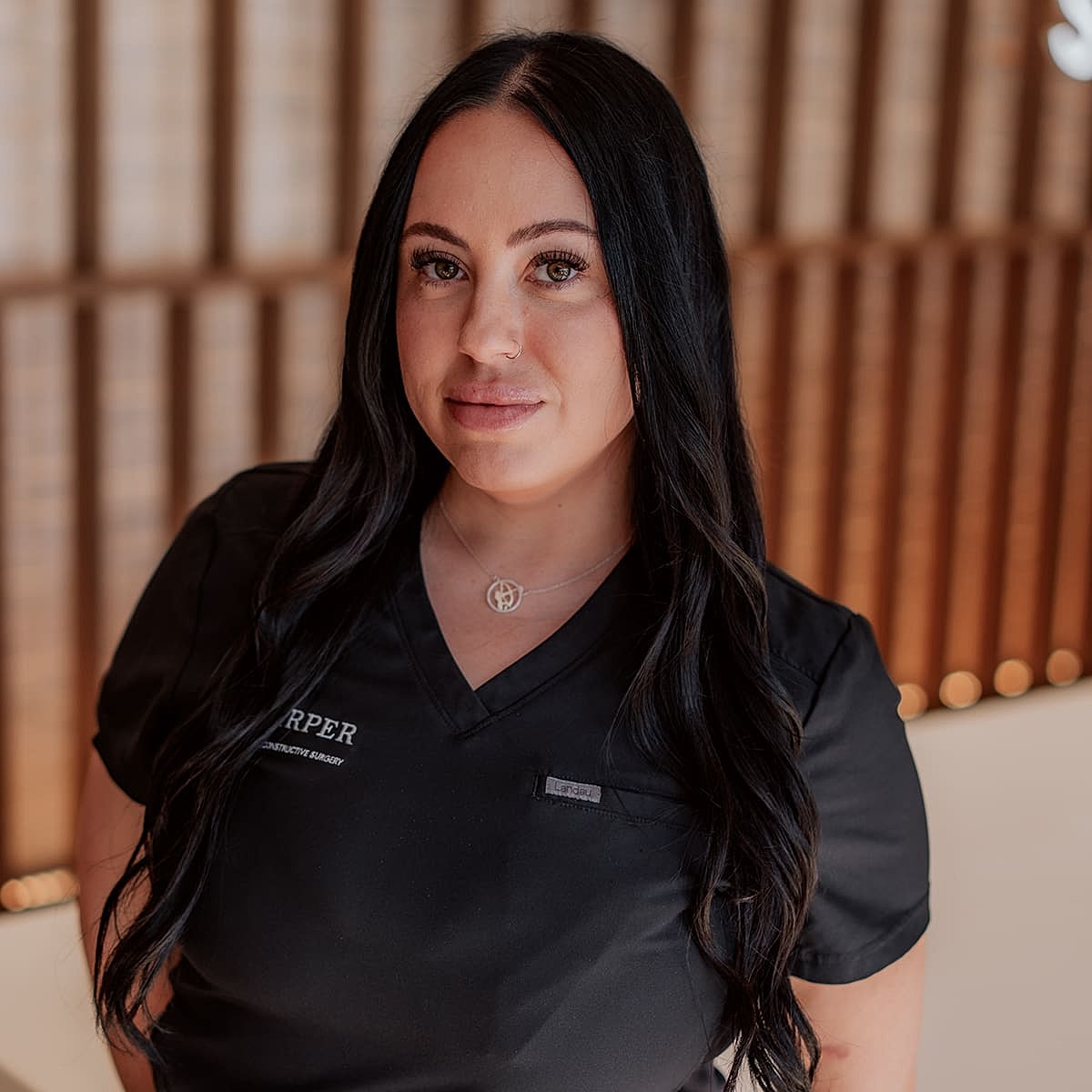 Woman in medical uniform with long black hair.