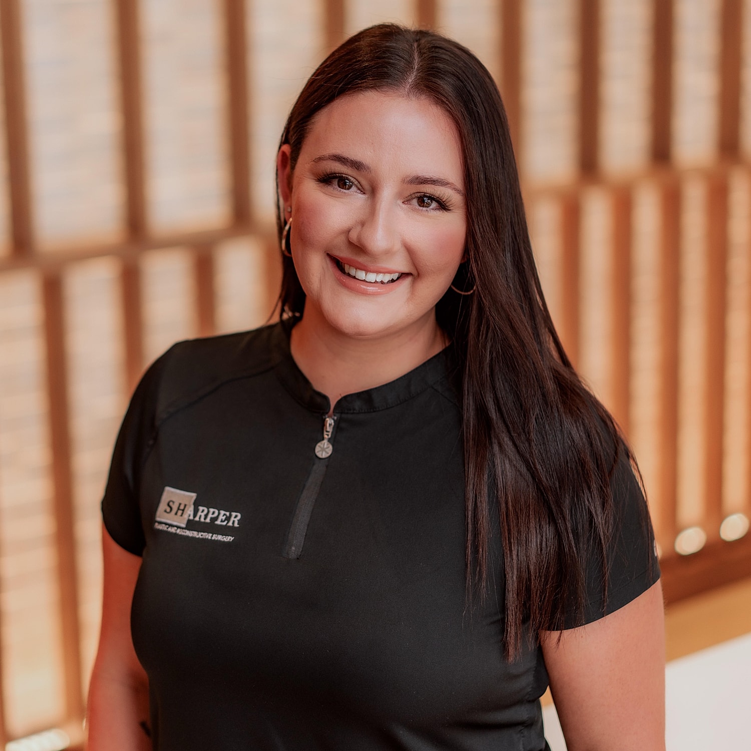 Professional smiling woman in healthcare attire.