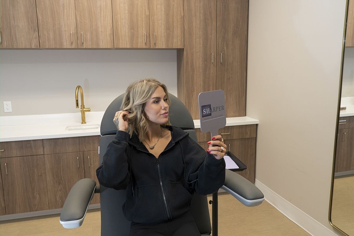 Woman examining herself in a salon mirror
