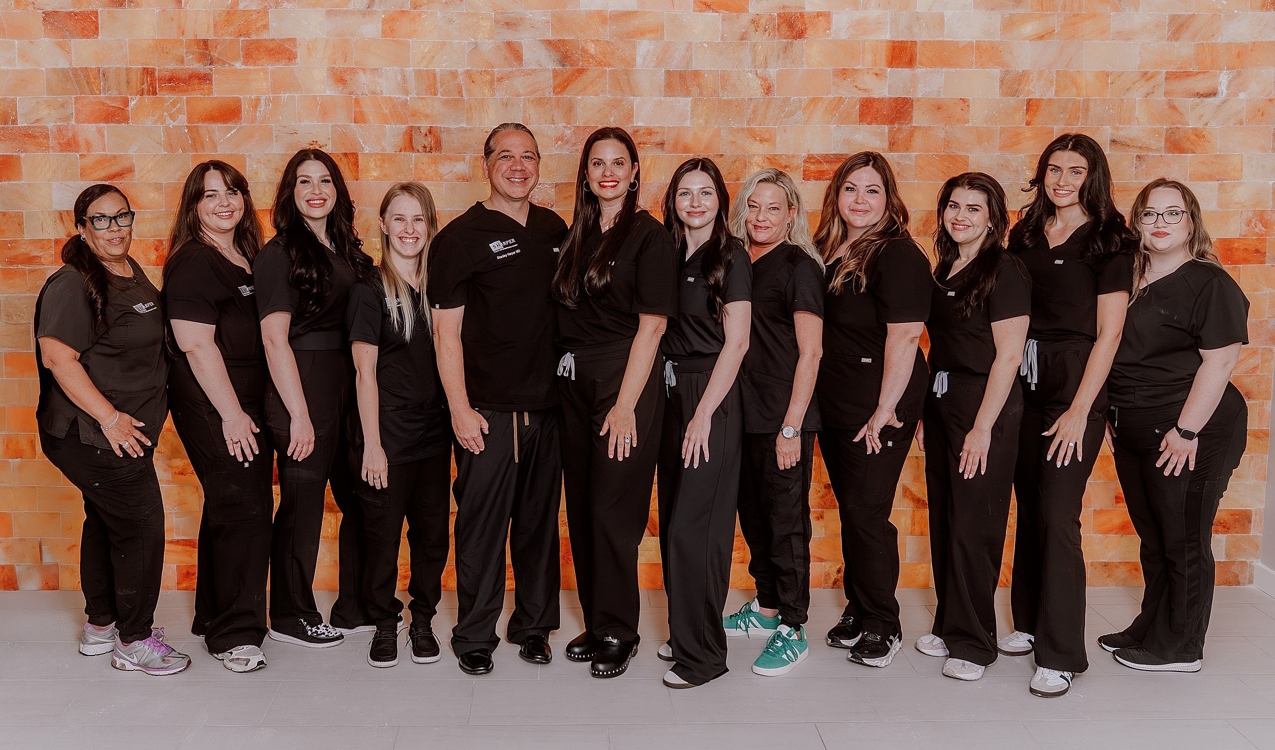 Group photo of healthcare professionals in black scrubs.